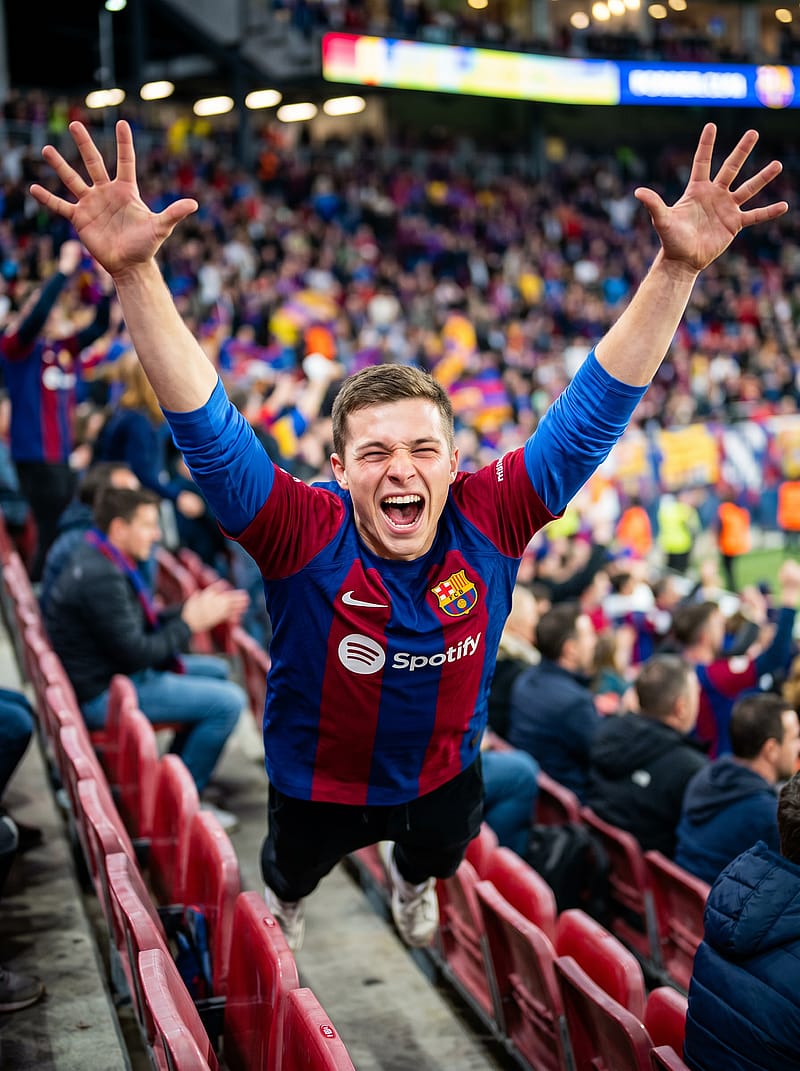Fan jumping and cheering on stadium bleachers with arms raised, colorful crowd and bright floodlights surrounding the scene.