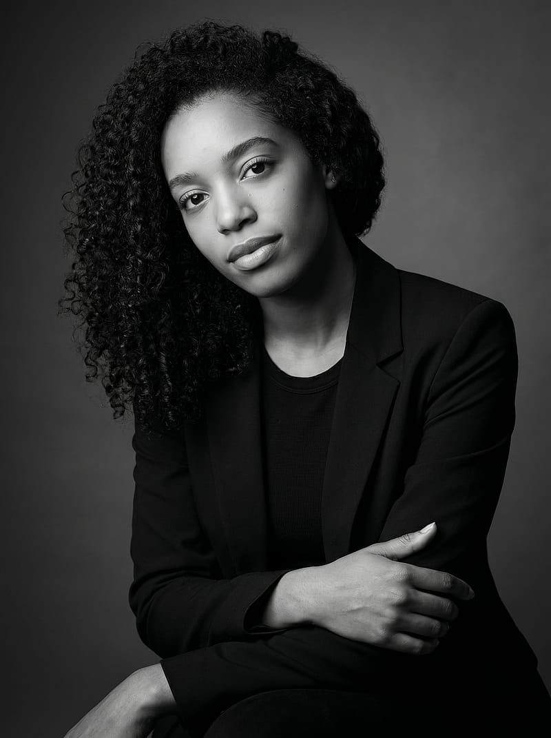 Black and white editorial portrait in a structured blazer with Rembrandt lighting, confident and refined mood.